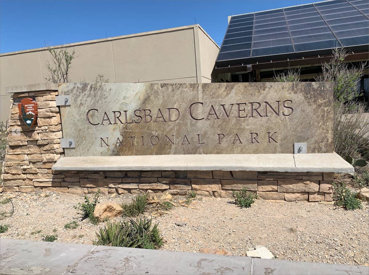Entrance sign for Carlsbad Caverns State Park with a clear sky in the background, highlighting it as a must-see attraction.
